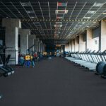A spacious gym with Pentz Carpet flooring, rows of treadmills on the right, and weight machines and exercise equipment along the left wall.